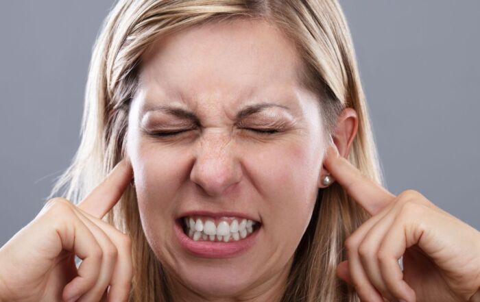 Woman covering ears because of noise
