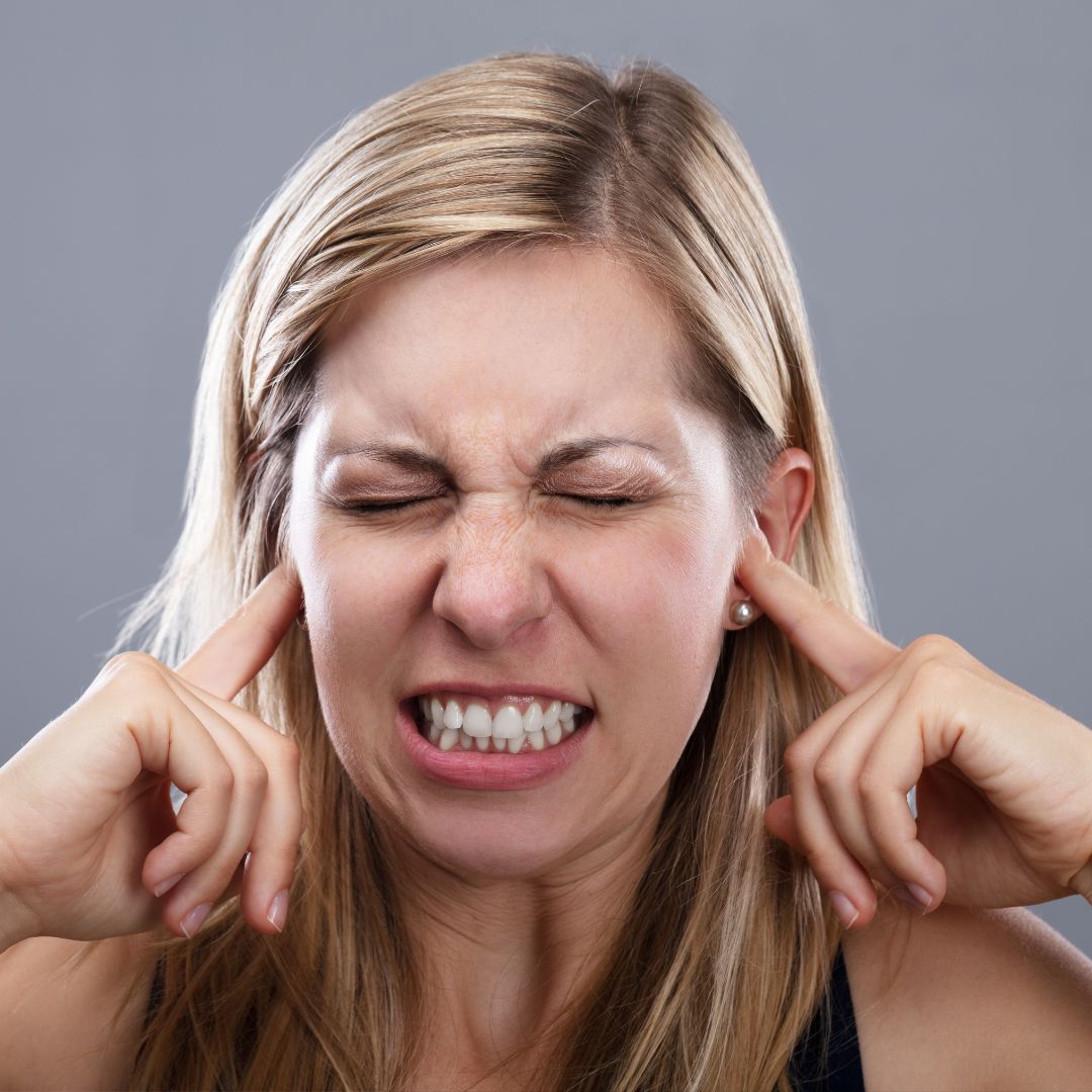 Woman covering ears because of noise